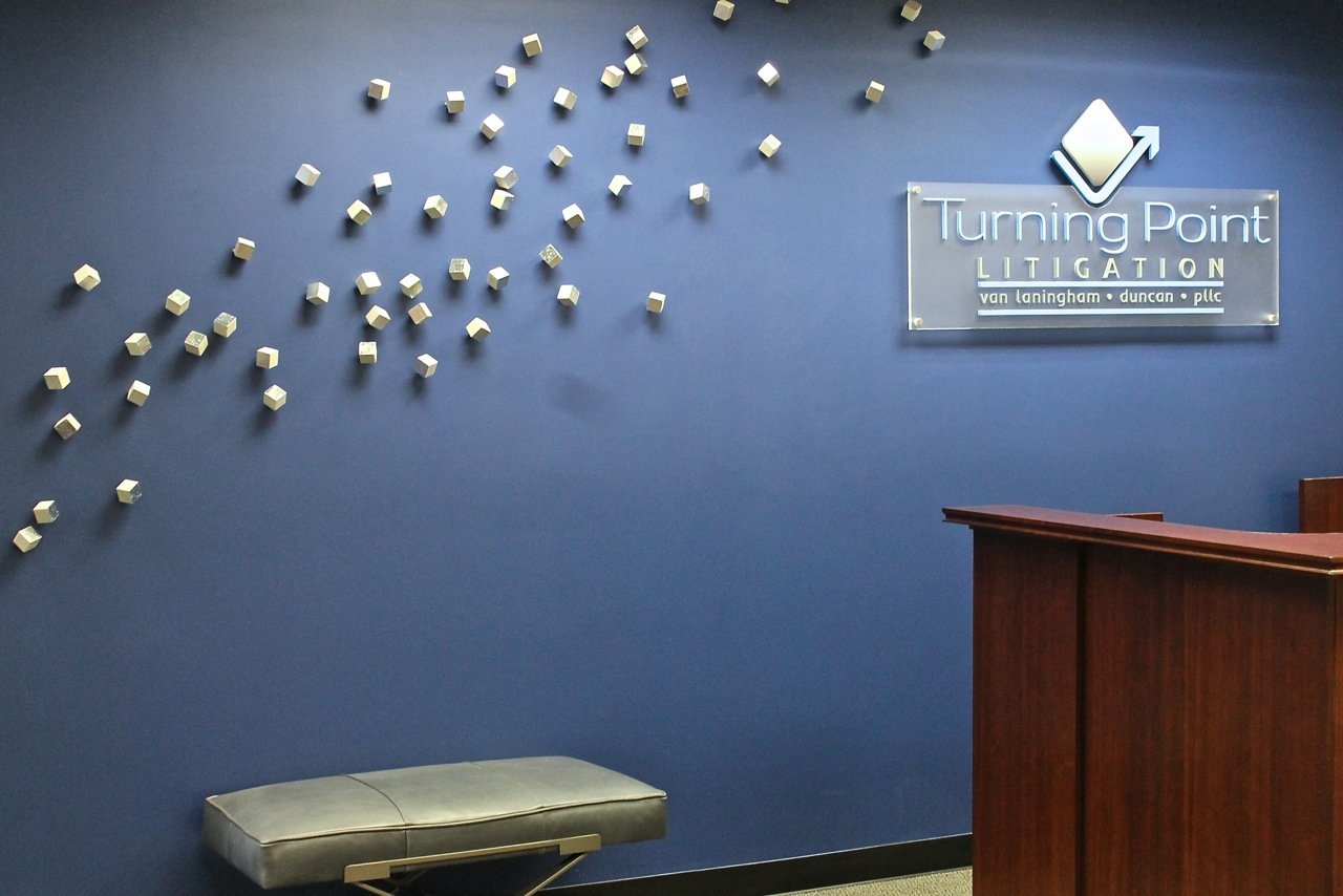 Law firm reception with a deep blue wall of sculptural white and silver cubes
