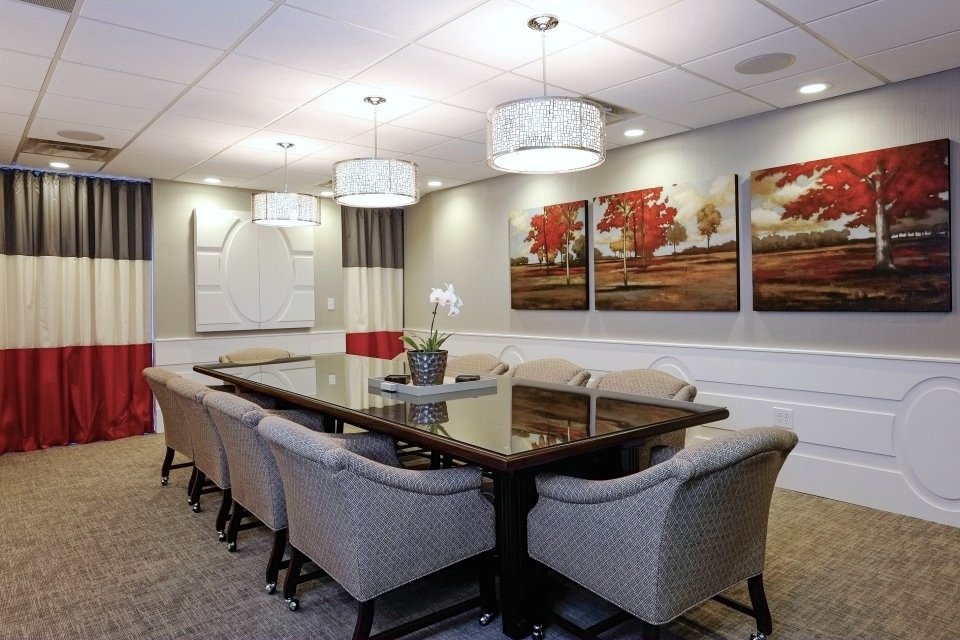 Ward Black Law conference room with red landscape paintings, pendant lights and gray upholstered chairs