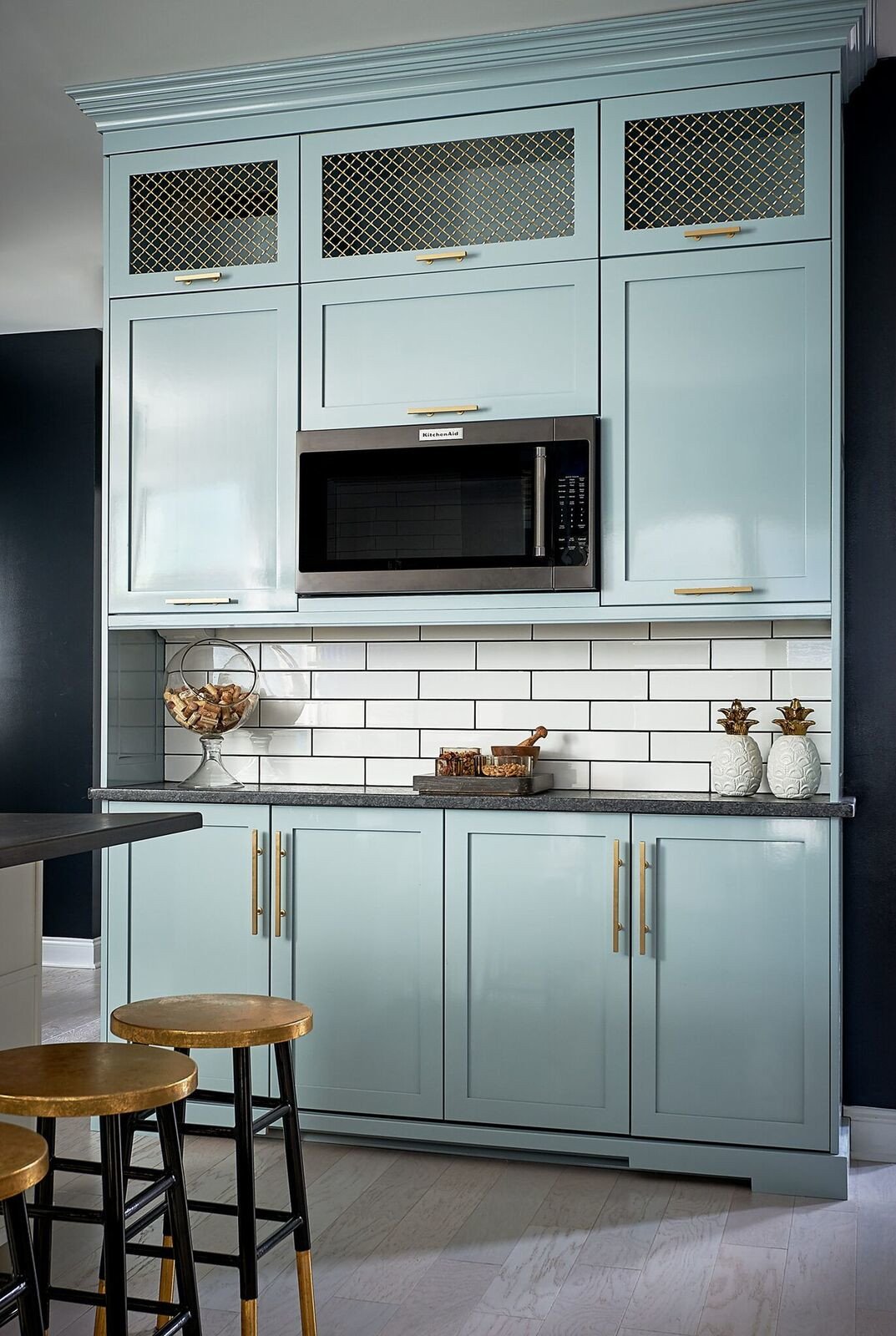 Robin's egg blue lacquered pantry wall with gold mesh inserts, brushed gold pulls and gold-topped stools