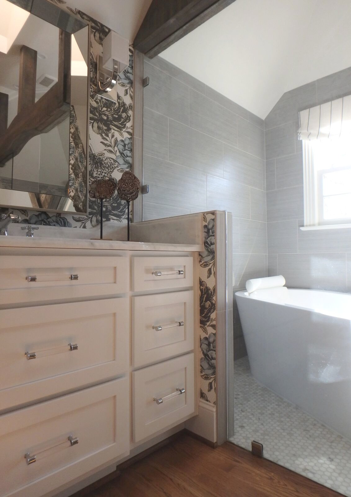 White vanity cabinetry with clear hardware and the soaking tub beyond