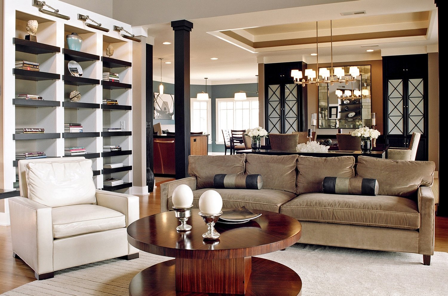 Open-plan great room at Tot Hill Farm with built-in shelving, a round walnut table and a view to the dining room